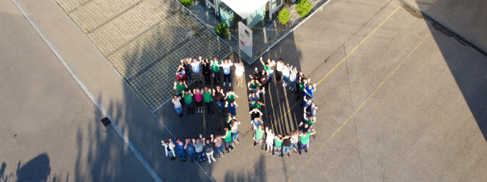 An aerial view of a group of people standing in the shape of the number 
