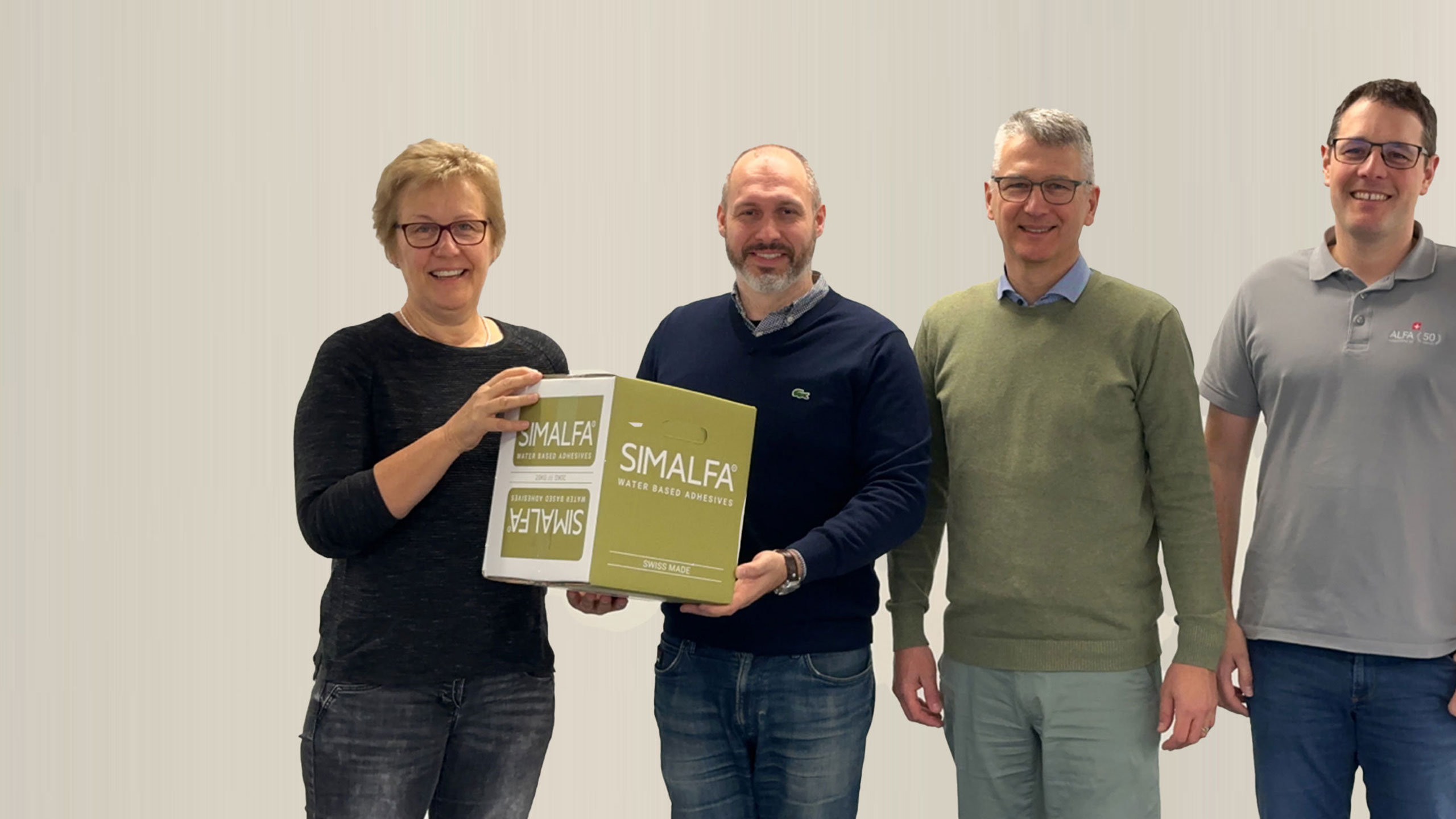 四个人合影，手持SIMALFA水性胶粘盒子