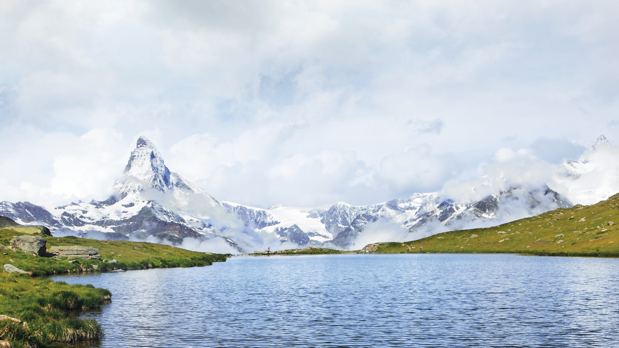 A serene view of the Matterhorn mirrored in the still waters of an alpine lake, capturing the pristine beauty of the Swiss Alps.