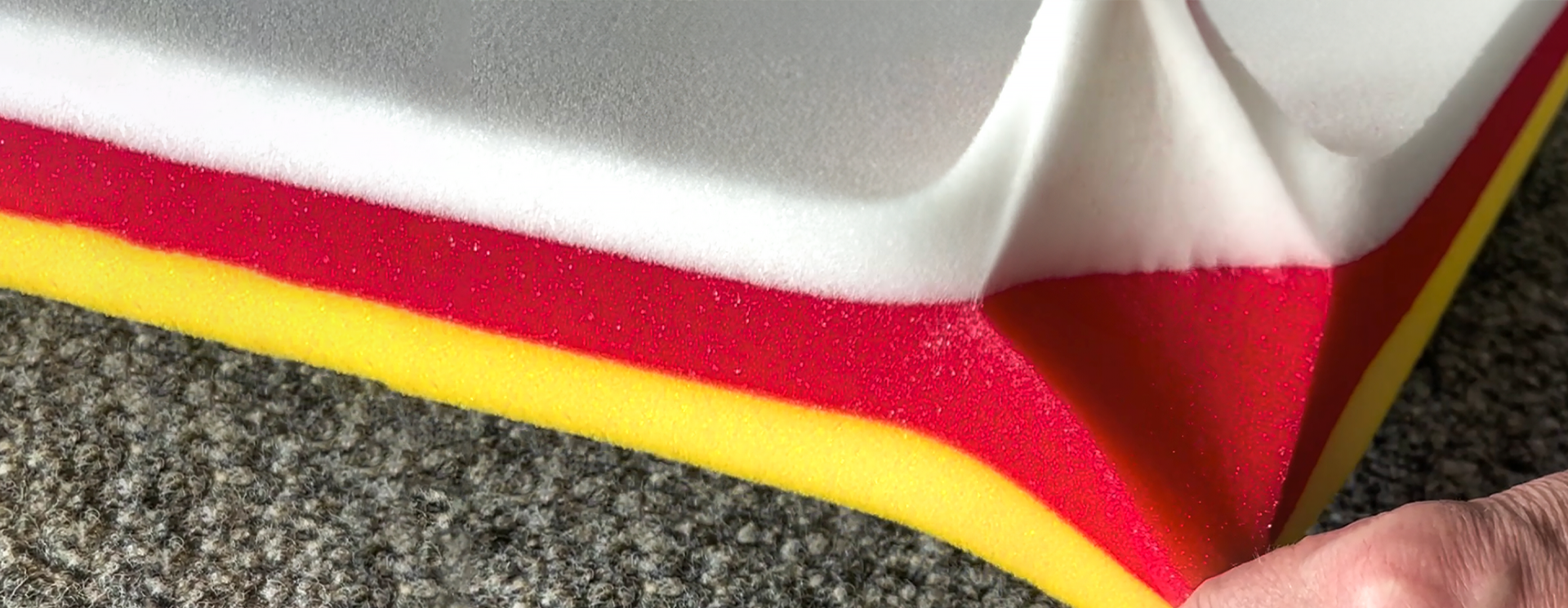 Hand pulling at a layered foam piece.