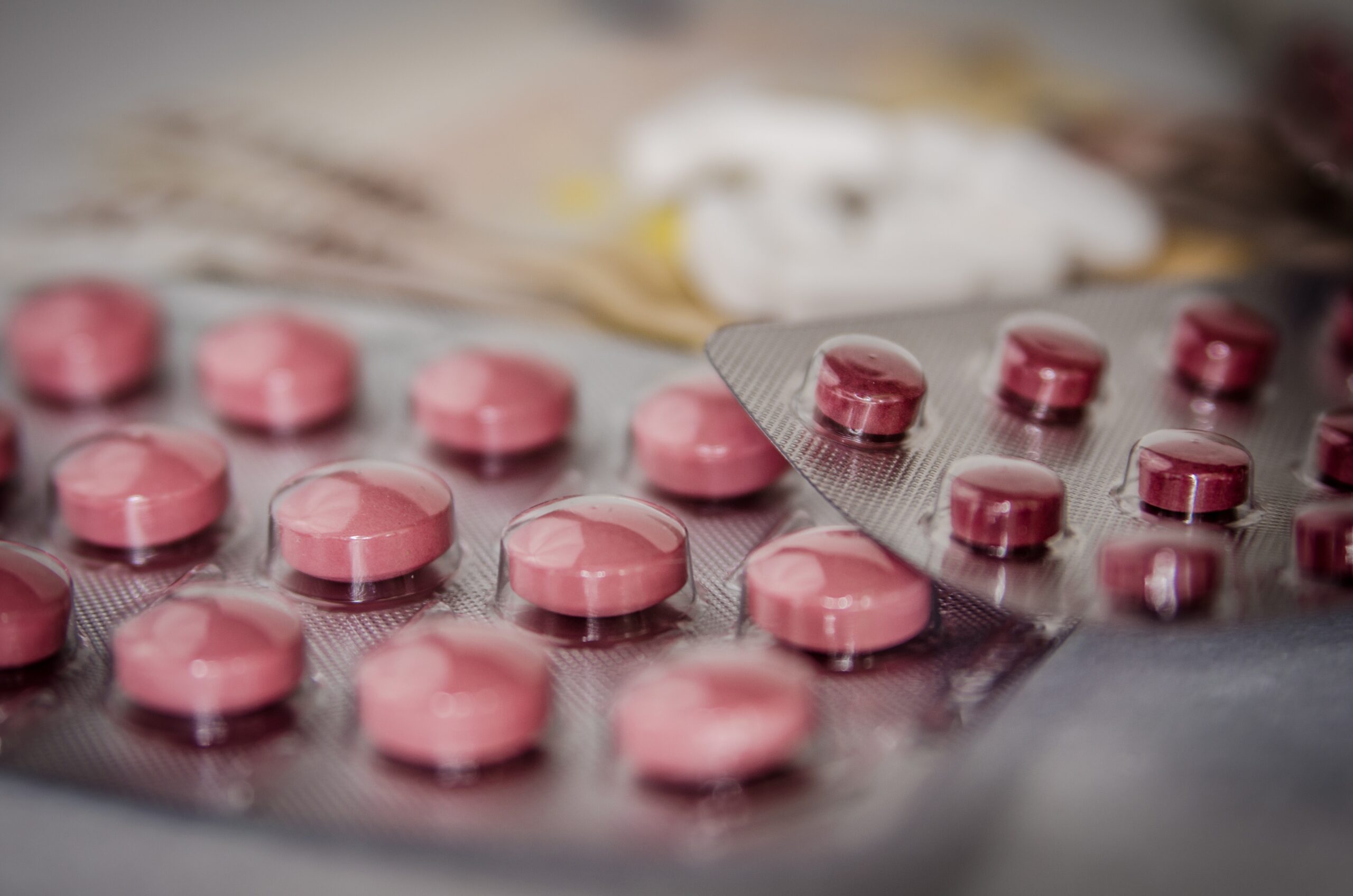 Nahaufnahme von rosafarbenen Tabletten in Blisterverpackungen, die auf einer Oberfläche liegen.