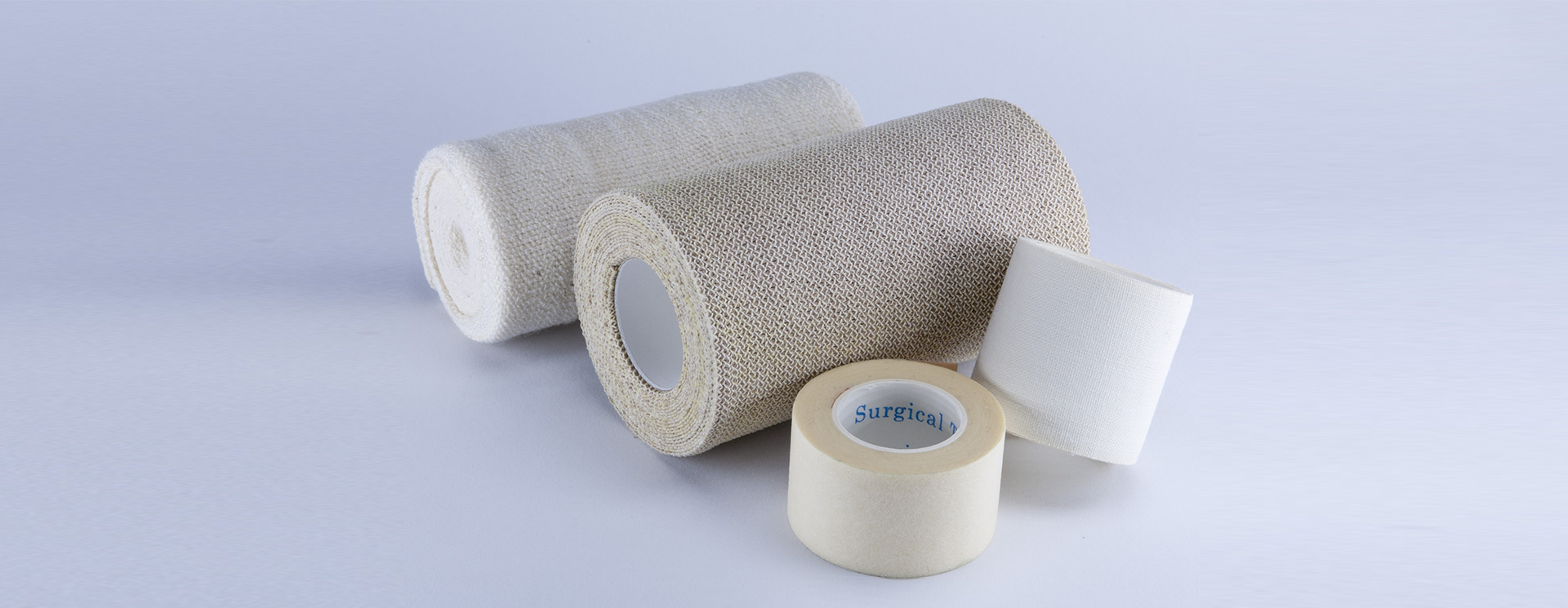 Neutral-colored fabric rolls neatly arranged, commonly used for furniture upholstery.
