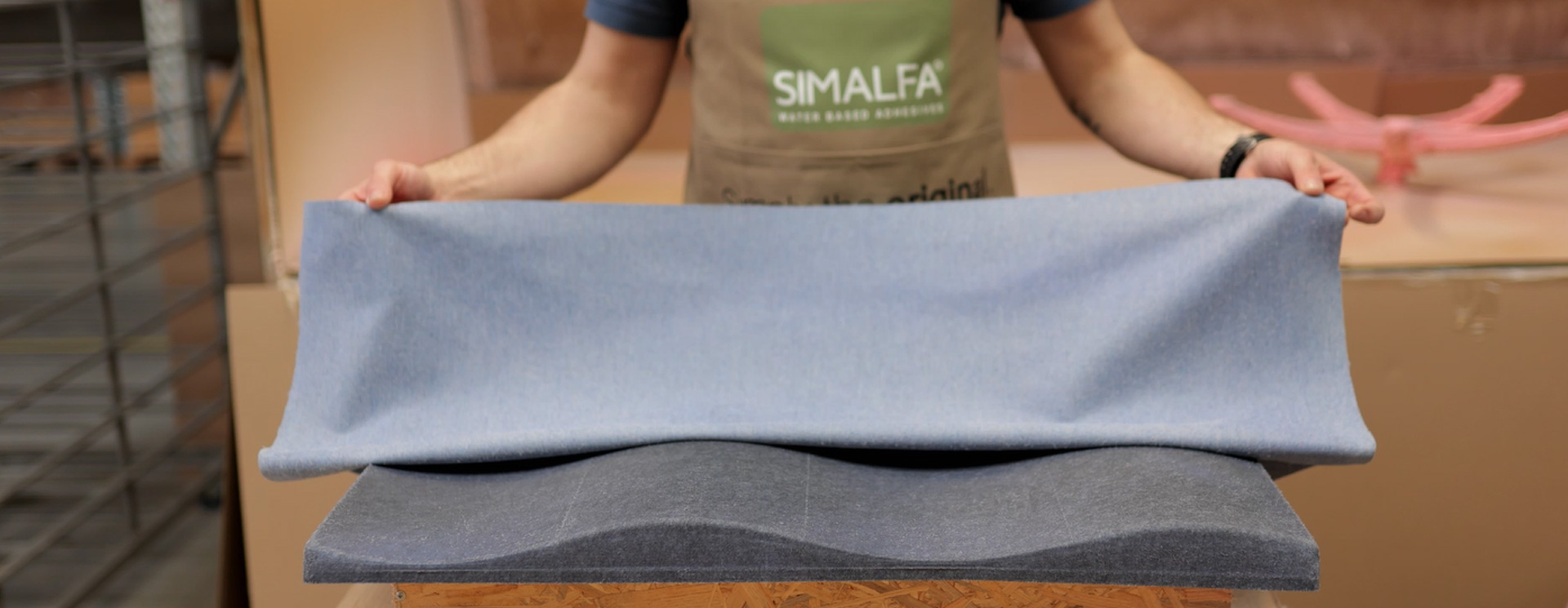 Person demonstriert die Anwendung von SIMALFA-Kleber auf einem Polster