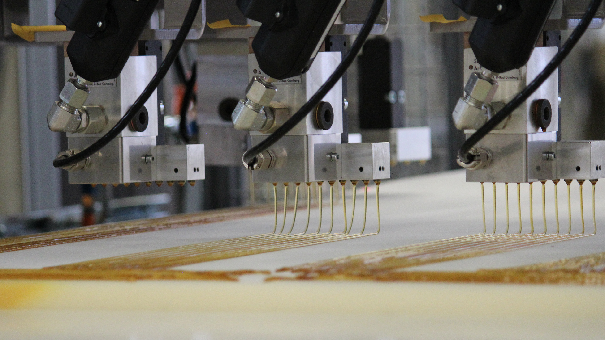 工业机器将粘合剂应用到表面上